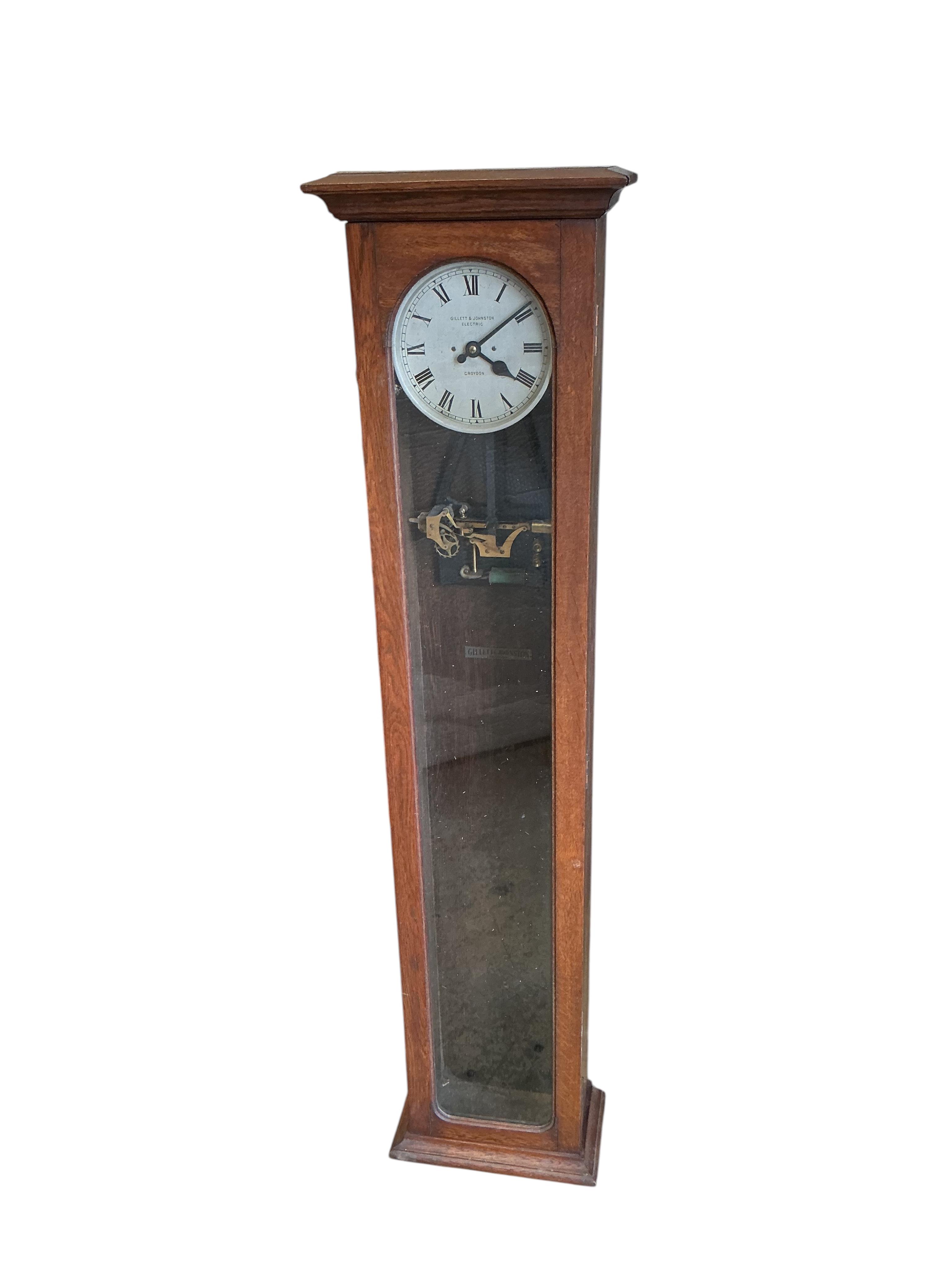 A Gillett & Johnston oak cased electric Master wall clock, with pendulum, height 139cm